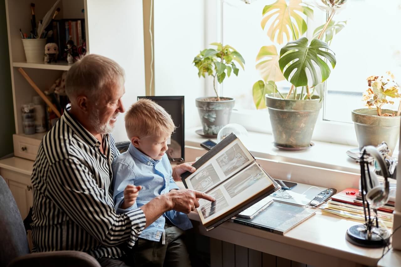 grandparent and grandson looking at photo album